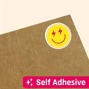 Detailed macro shot of a yellow smiley face self-adhesive sticker applied to cardboard
