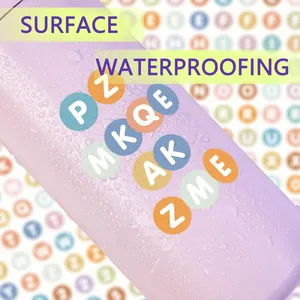 Close-up of waterproof alphabet dot stickers on a purple surface with water droplets.