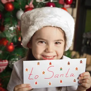 Primer plano de pegatinas de hombre de jengibre en un sobre blanco para la carta a Santa Claus
