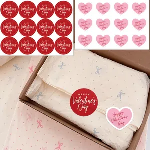 Detailed view of red round and pink heart Valentine's Day sealing stickers on gift box.