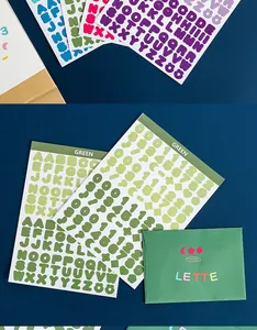 Detailed view of green bubble alphabet and number sticker sheets on blue background