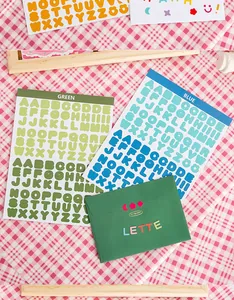 Macro view of green and blue alphabet sticker sheets for DIY scrapbooking decoration