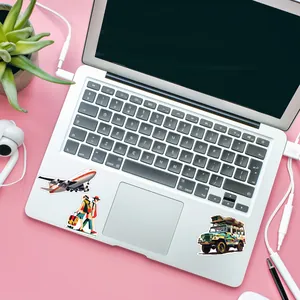 Detailed view of vibrant travel-themed graffiti stickers applied to a silver laptop surface