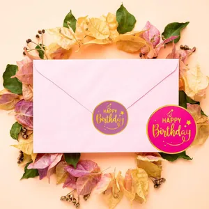 Pink envelope sealed with purple Happy Birthday sticker surrounded by autumn leaves