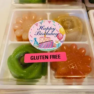 Detailed macro view of Happy Birthday and Gluten Free adhesive stickers on a clear food box