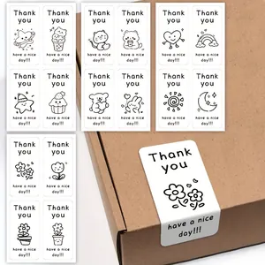 Detail of cartoon doodle thank you stickers applied on a cardboard gift box.