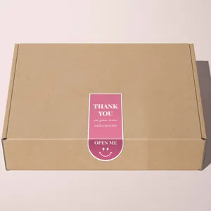 Pegatina rosa de agradecimiento en forma de U que sella una caja de regalo de cartón