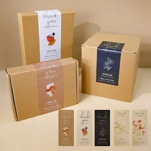 Verschiedene minimalistische rechteckige „Thank You“-Siegelaufkleber auf Kraftpapierboxen