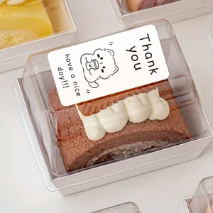 Detail showing a cute bear 'Thank You' sticker on a clear plastic cake box lid.