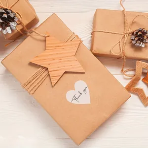 Close-up of heart-shaped 'Thank you' sticker on a rustic kraft gift box packaging