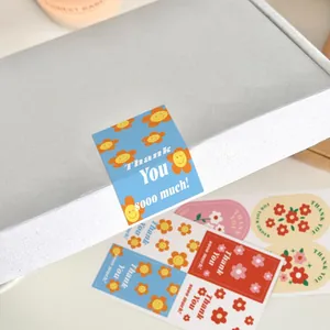 Close-up view of rectangular floral Thank You stickers used for sealing a gift box