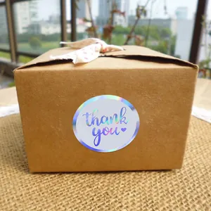 Close-up of 5cm round holographic laser sticker with thank you text on a box