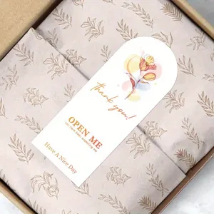 Close-up detail of floral 'Thank You' seal sticker on elegant gift box packaging tissue