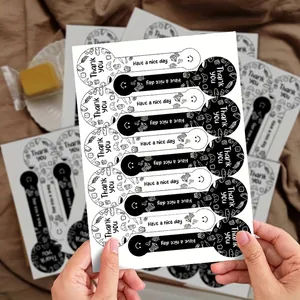 Primer plano de pegatinas 'Thank You' en blanco y negro para sellar cajas regalo