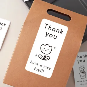 Close-up of Thank you sealing sticker with cute tulip on brown gift bag