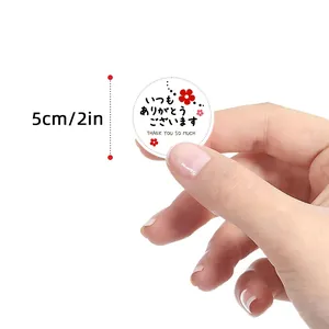 Close-up of a 5cm round Japanese thank you sticker being held against white background