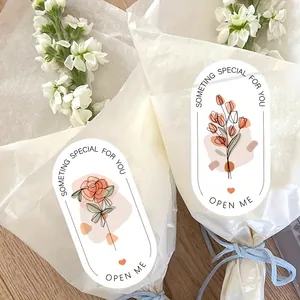 Close-up of elegant floral sealing stickers on white flower bouquet packaging
