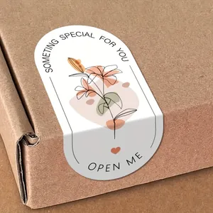 Detailed macro view of an elegant floral sealing sticker on a brown kraft gift box.
