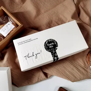 Detalle de una caja de regalo blanca con una pegatina de sello negra 'Thank You' elegante
