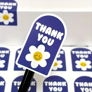 Nahaufnahme eines blauen Aufklebers mit weißer Blume und Thank You Aufschrift