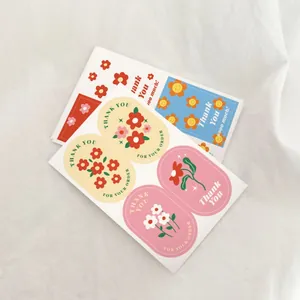 Close-up detail of cartoon flower thank you stickers for gift box sealing and baking