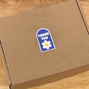Blauer bogenförmiger Dankesaufkleber mit Blumenmuster auf einem braunen Karton