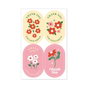 Close-up detail view of four cute floral thank you stickers for gift sealing and baking.