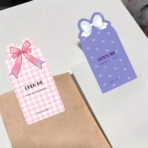 Detailansicht von rosa und lila Schleifen-Aufklebern auf verschiedenen Geschenktüten