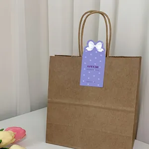 Detail eines lila bogenförmigen Siegelaufklebers mit 'OPEN ME' Text auf Geschenktüte