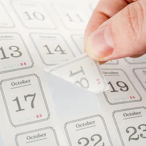 Close-up detail of undated monthly calendar stickers being peeled for custom planner use