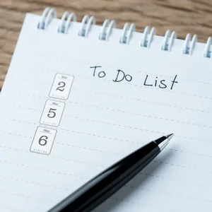 Close-up detail of May date stickers placed on a white spiral notebook to-do list