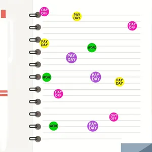 Close-up of colorful round planner stickers with work and pay day labels on notebook