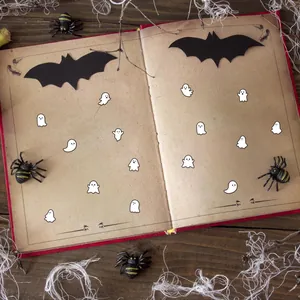 Autocollants fantômes DIY Halloween aux expressions mignonnes sur un livre vintage