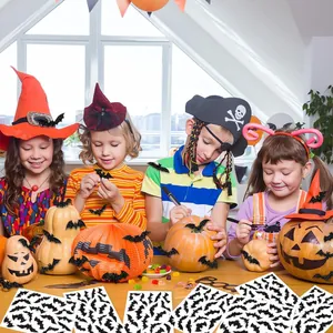 Enfants décorant des citrouilles avec des autocollants de chauve-souris pour Halloween DIY