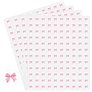 Detail van meerdere vellen met roze aquarel strik cirkelvormige stickers voor decor