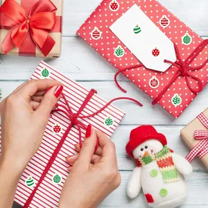 Vista detallada de pegatinas navideñas festivas aplicadas en envoltorios de regalo DIY