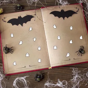 Detalle de lindas pegatinas de fantasmas para scrapbooking en un libro de Halloween.