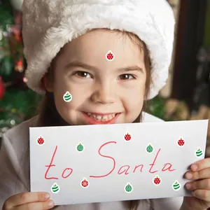 Vista detallada de mini pegatinas de Navidad en un sobre festivo y en la cara de niña