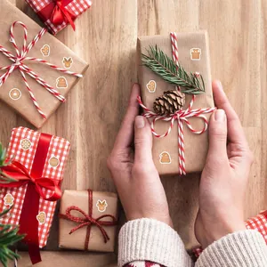 Mini pegatinas navideñas con diseños de jengibre y renos aplicadas en regalos