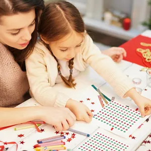 Madre e hija usando pegatinas de estrellas de Janucá para manualidades festivas DIY