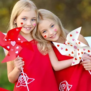 Vista detallada de pegatinas de corazones rojos y rosas en caras de niños y molinos