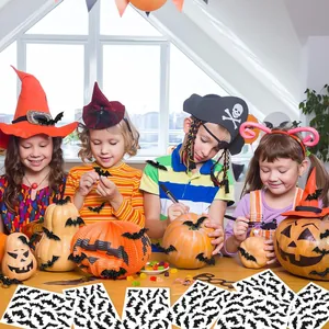 Detail showing children decorating pumpkins with black glitter Halloween bat stickers.
