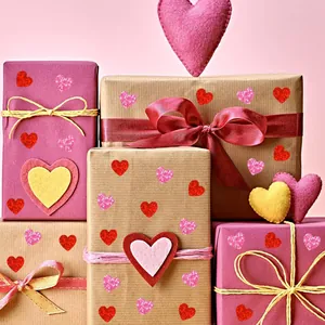 Vista detallada de pegatinas de corazón láser rojas y rosas en cajas de regalo para San Valentín.