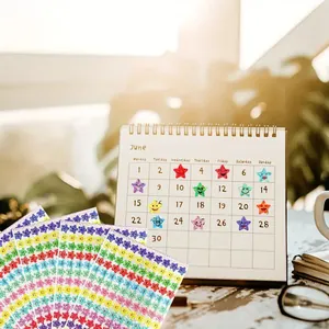 Macro view of colorful laser smiley star stickers applied to a June monthly calendar