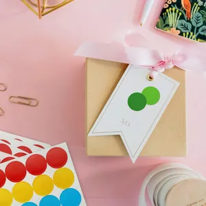 Macro detail of colorful 19mm round dot stickers applied on a white gift tag for DIY