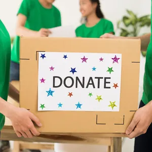 Vibrant holographic star stickers decorating a white donation sign on a cardboard box