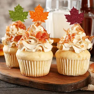 Detail view of glitter autumn maple leaf stickers used as festive cupcake toppers.