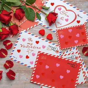 Pegatinas de corazón láser rojas y rosas en románticos sobres de San Valentín