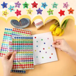 Close-up of glitter star smiley stickers being applied to a notebook page.