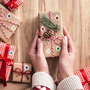 Mini glittery laser Christmas ball stickers decorating a rustic brown gift box wrapping